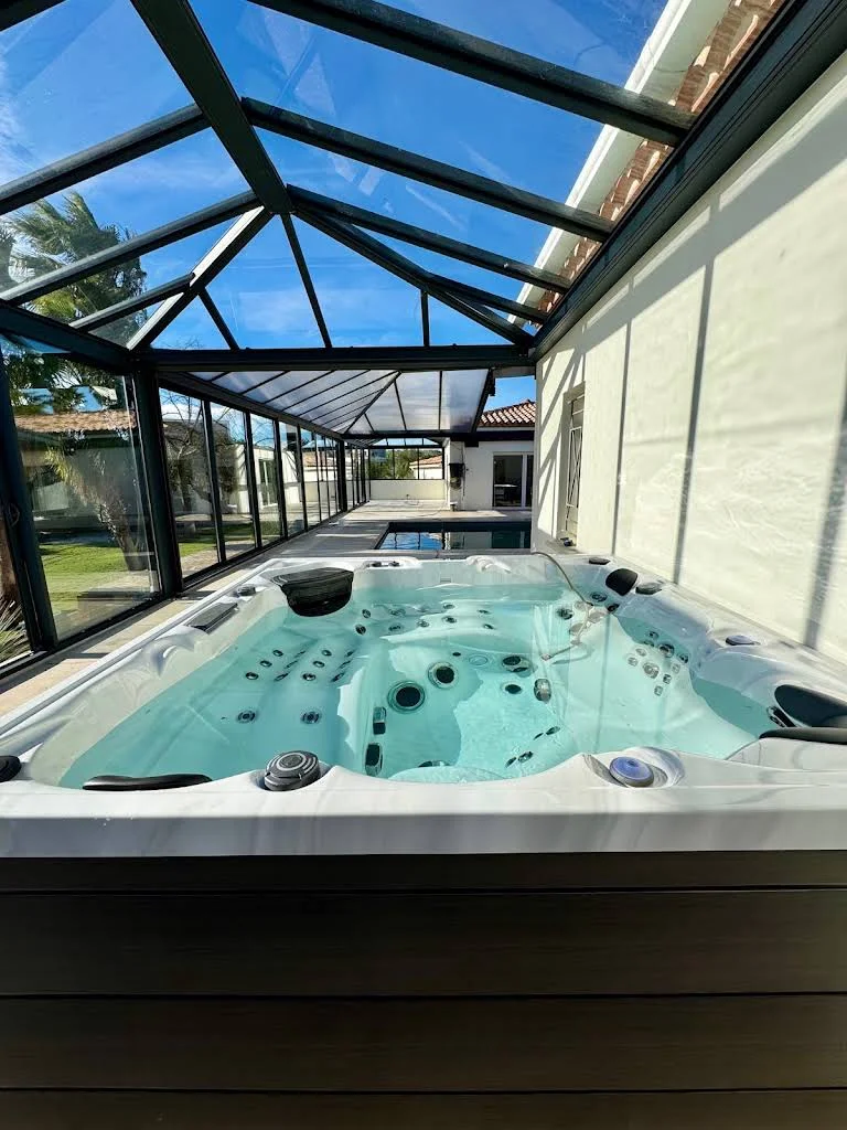 Spa installé sous une véranda lumineuse